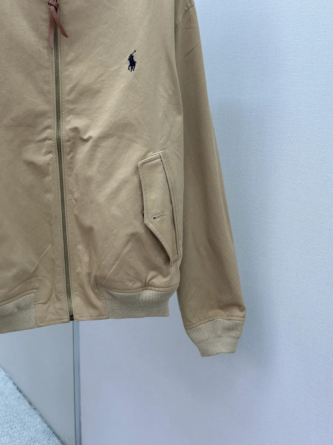 P550 Ralph Lauren embroidered zipper jacket. Customized elegant cotton fine twill fabric. Soft and silky. Comfortable against the skin. With khaki as the base color. Soft and unobtrusive. Just right to show a kind of restrained elegance. Exquisite pony logo is embellished with it. It brings an atmosphere of freedom and vitality and injects the soul charm of the brand. Simple and smooth lines outline a tall and straight figure. A unique and charming fashion masterpiece emerges. Process 1: Use imported machine embroidery process. Use advanced computer control systems and precision mechanical components to achieve the iconic pony embroidery operation with high precision and smooth and delicate lines. Process 2: Template machine bag opening. The preset template guides the position, shape and size of the bag opening. The accuracy ensures the quality of the bag opening effect. Process 3: Infrared positioning cutting bed uses infrared emitters and infrared receivers to achieve precise positioning of materials. The accuracy can reach the micron level, thereby meeting the effect of high-precision cutting of plaid alignment. Process 4: The fabrics are washed. Better hand feel, not easy to deform, not easy to shrink, not easy to fade, maintain long-term beauty Accessories: Customized Ralph Lauren horn buckle, Customized Ralph Lauren zipper, Customized leather lanyard, Customized Ralph Lauren trademark Version: Loose version Size: S M L XL